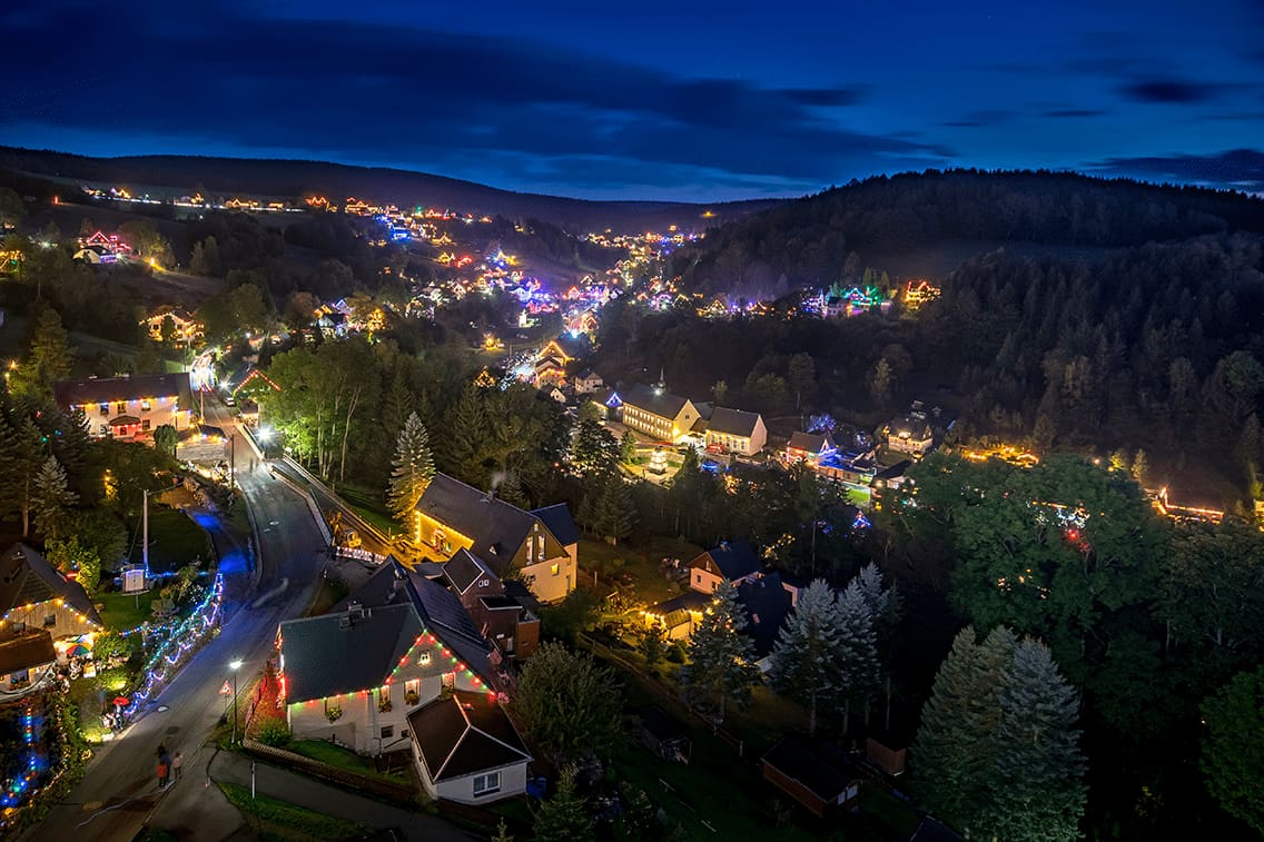 Die leuchtenden Häuser des Pobershauer Bergfests in Sachsen bei Nacht.