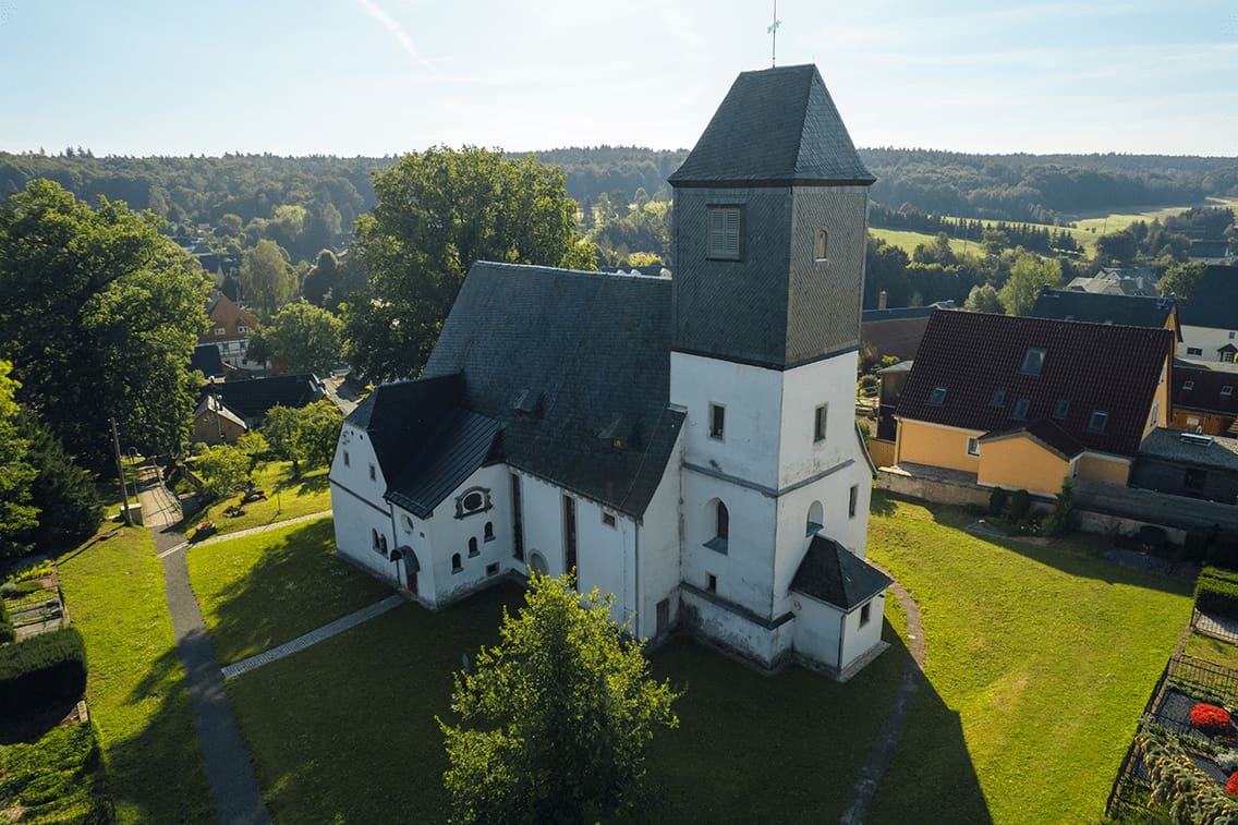 Die Höckendorfer Kirche in Sachsen von der Seite im Sommer.