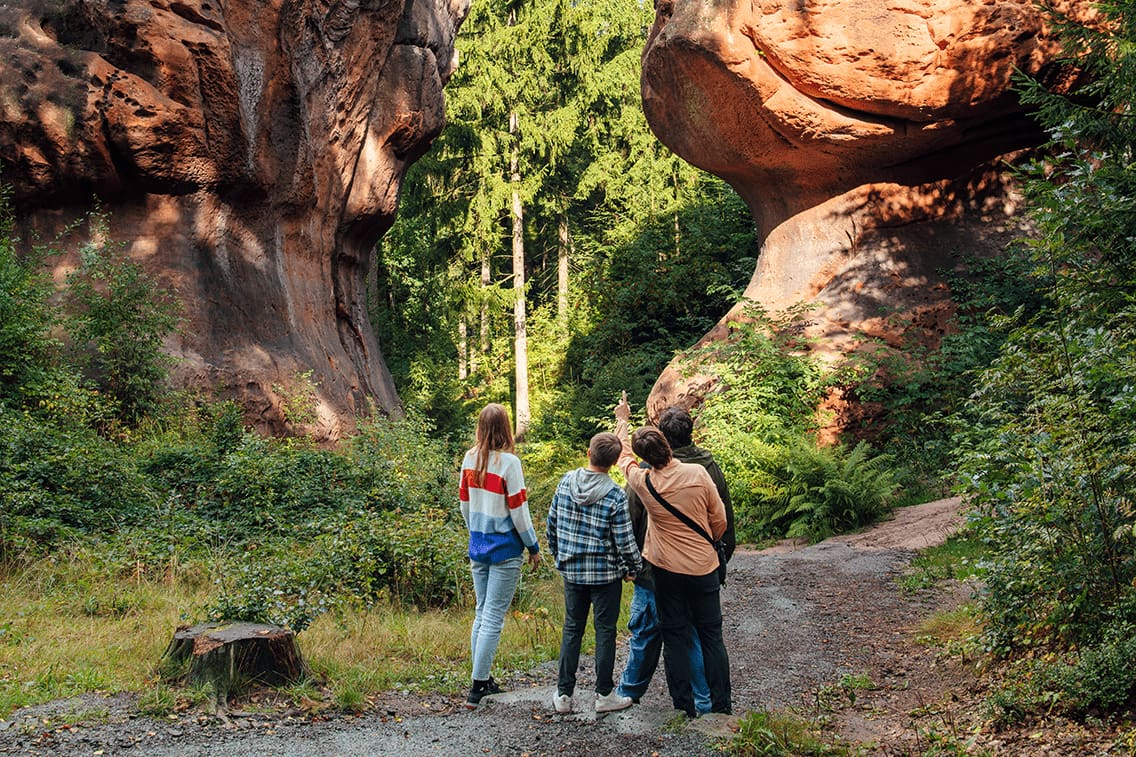 Eine Familie steht vor 17 Meter großen Steinen in Form von Kelchen.