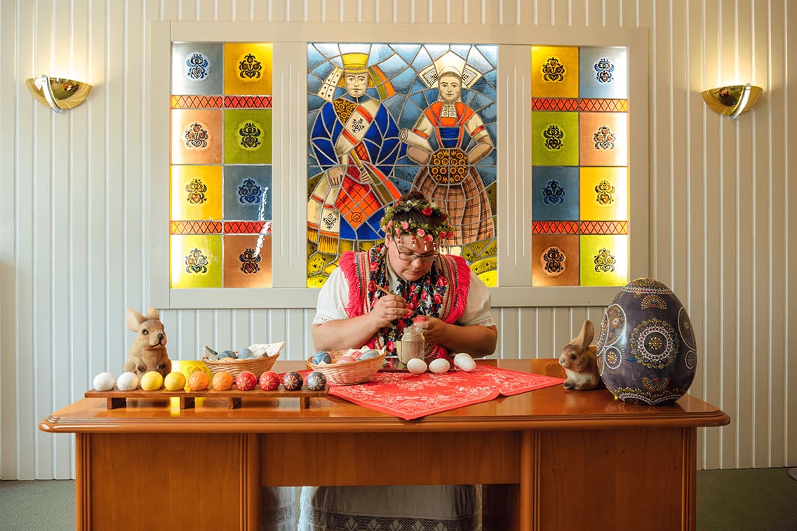 Die Frau bemalt auf ihrem Schreibtisch Ostereier für das Osterfest.