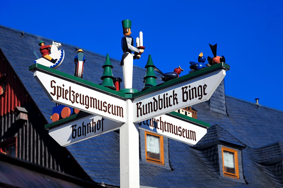 Ein Holzpfad in Seiffen mit bunten Holzmännern darauf.