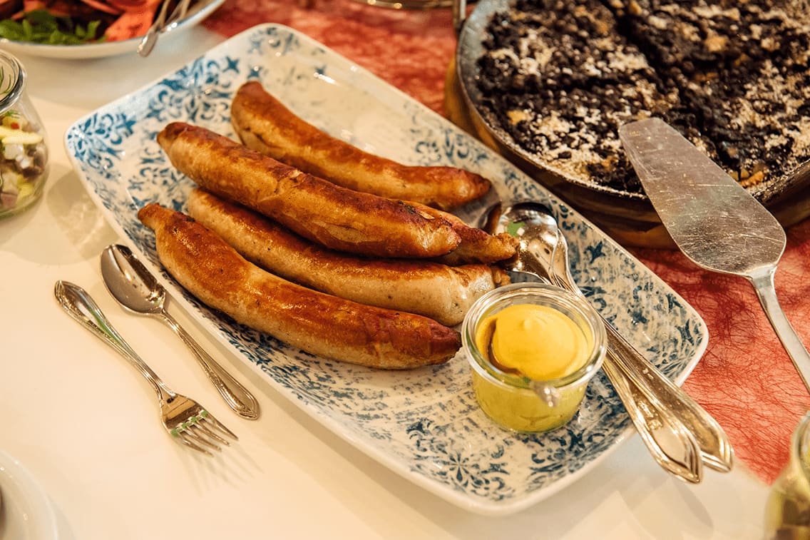 Bratwürste mit Senf auf einem Teller.