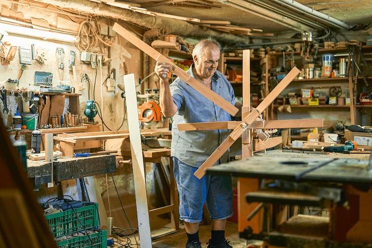 Ein Handwerker in seiner Werkstatt, in der er das Windrad aus Holz per Hand baut.