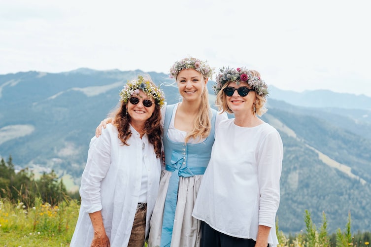 Paula Bründl und zwei weitere Frauen mit aufgesetzten Blumenkränzen am Hochkönig.
