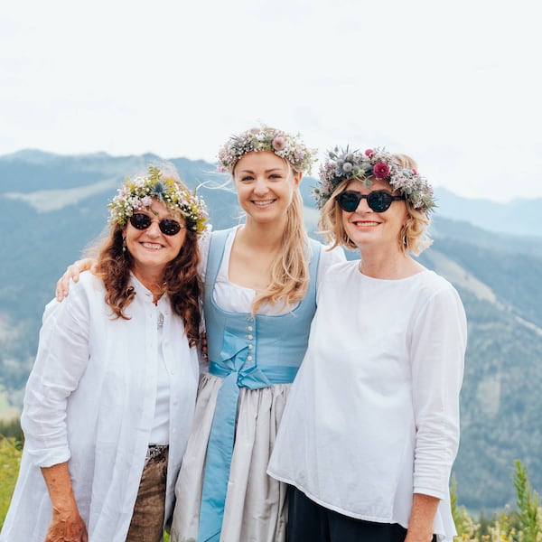 Paula Bründl und zwei weitere Frauen mit aufgesetzten Blumenkränzen am Hochkönig.