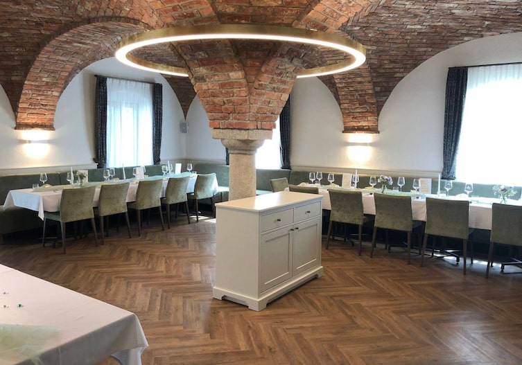 Umgebautes Kellergewölbe mit vielen Sitzmöglichkeiten (Tafel) den Wänden entlang