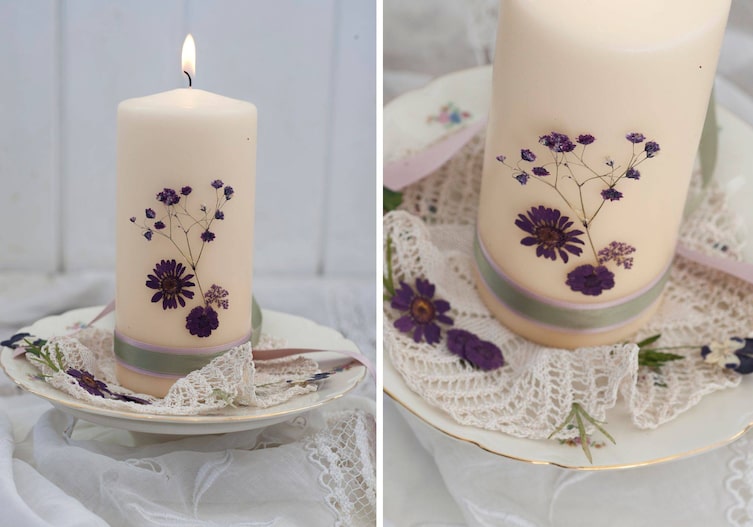 Brautkerze, Hochzeitskerze au feinem alten Teller mit geschwungenem Goldrand. Die Kerze ist weiß, sie brennt und ist mit violetten, getrockneten Blumen verziert.