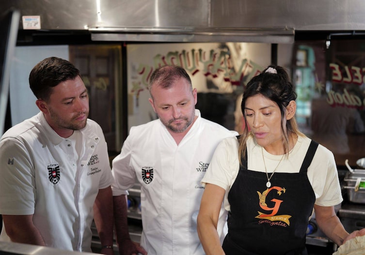 Fritz und Tamino Grampelhuber und Bricia Lopez vom Restaurant Guelaguetza in ihrer Küche. Sie schauen ihr beim Kochen zu.