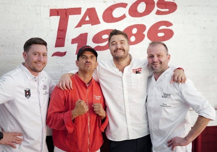 Fritz, Tamino Grampelhuber und Jorge Joy Alvarez Tostado und Victor Delgardo vor einer weißen Wand auf der Tacos 1986 steht.