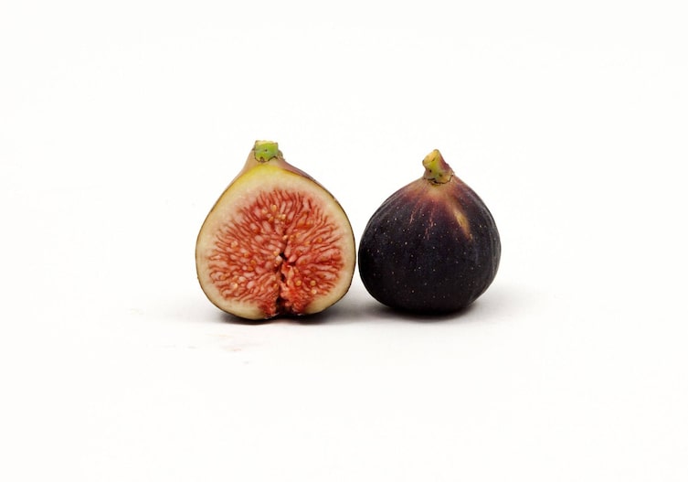 Typische Feige, leicht bauchig, außen violett, innen rotes helleres Fruchtfleisch, halbiert, von vorne und von hinten fotografiert.