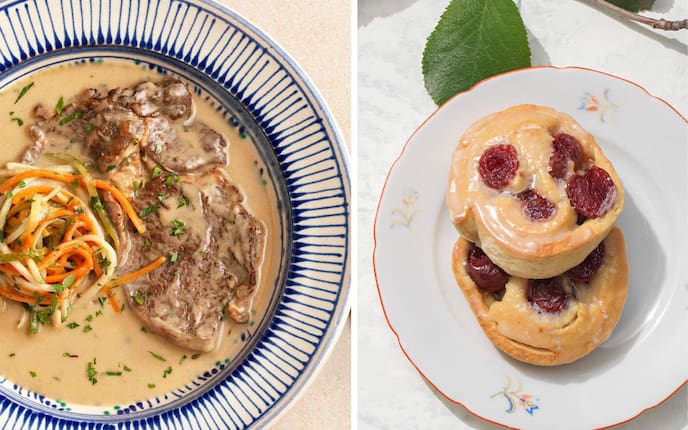 Eszterházy-Rostbraten mit Saft und feinen Gemüsestreifen auf einem blau gestreiftem Teller angerichtet. Zwei Germteigschnecken mit Kirschhälften auf einem Desserteller