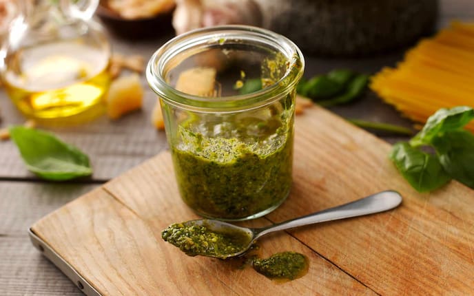 Pesto, Glas, Rexglas, Holzbrett, Löffel, Öl, Basilikumblätter, Käse