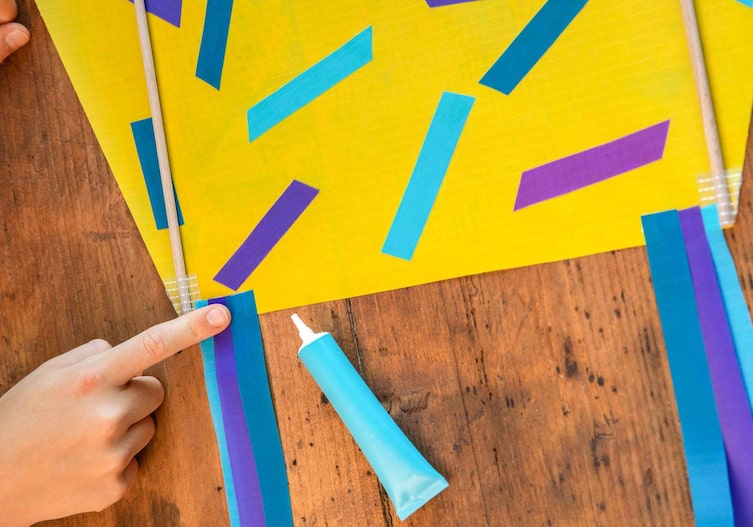 Die Bänder werden am Drachen befestigt mit einem Klebstoff.