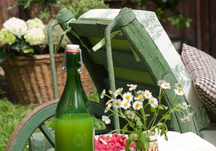 Ausrangierter Schubkarren aus Holz in grün, wird zu einem Liegestuhl.