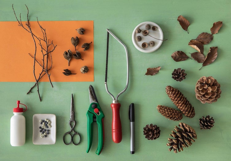 Zweige, verschiedene Zapfen, Blätter, Eicheln, Stift, Säge, Schere, Zange, Holzperlen, Kleber