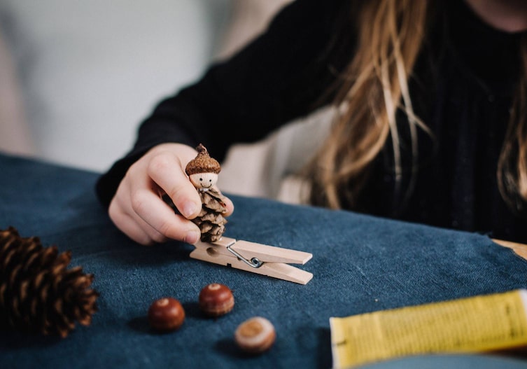 Kinderhand drückt das fertige Wichtel-Bockerl auf eine Holzkluppe