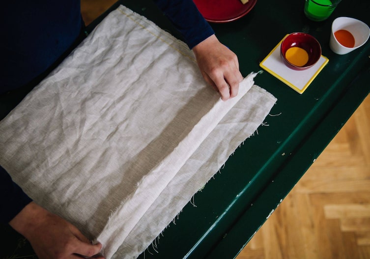 Stoff wird am offenen Ende umgeschlagen, um dort einen Tunnel zu nähen durch den die Schnur durchgeht.