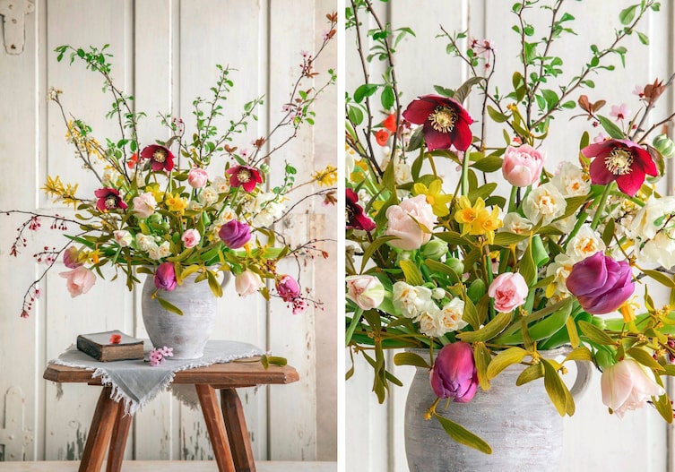 Frühlingsblumenstrauß in einer grauen Tonvase. Steht auf einem Holztisch mit einem kleinen grauen Tischtuch und einem alten Buch darauf. Der Tisch steht vor einer weißen schäbigen Holzvertäfelung, vielliecht auch eine Tür.