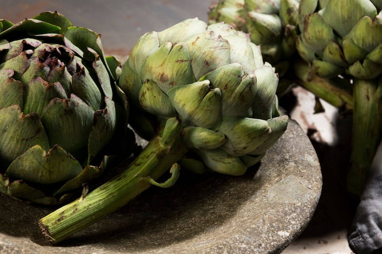 Nahaufnahme einer Steinschale mit Artischocken darin