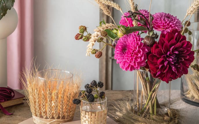 Kerzengläser mit Ähren außen verziert, Blumenstrauß mit Dhalien, um die Vase sind Ähren gelegt.