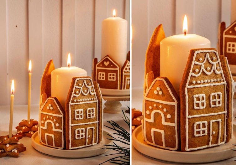 Lebkuchenkekse in Form von Häuserfronten dekoriert und rund um eine dicke große Stumpenkerze drapiert. Daneben stehen ganz dünne Kerzen, die als Kerzenständer in verzierte Lebkuchensterne gesteckt sind.