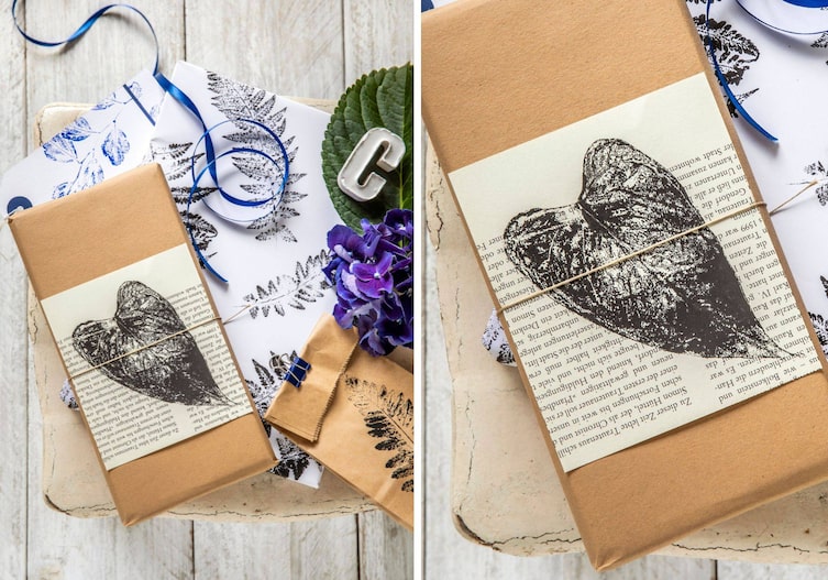 Eine weißer Vintage-Untergrund, weißes Papier mit Pflanzenblätter-Linoldruck in der Farbe schwarz und blau. Eine blaue Hortensienblüte liegt daneben. Ein kleines Papiersackerl mit Blattdruck (ein Farn). Ein Buch ist in braunem Papier eingewickelt darüber ist ein Stück von einer Buchseite gelget mit einem Blattdruck darauf. Alles zusammen ist mit einer braunen Schnur zusammengeschnürt.