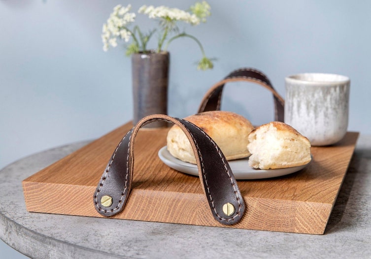 Holztablett mit Ledergriffen mit Gebäck und einer Tasse