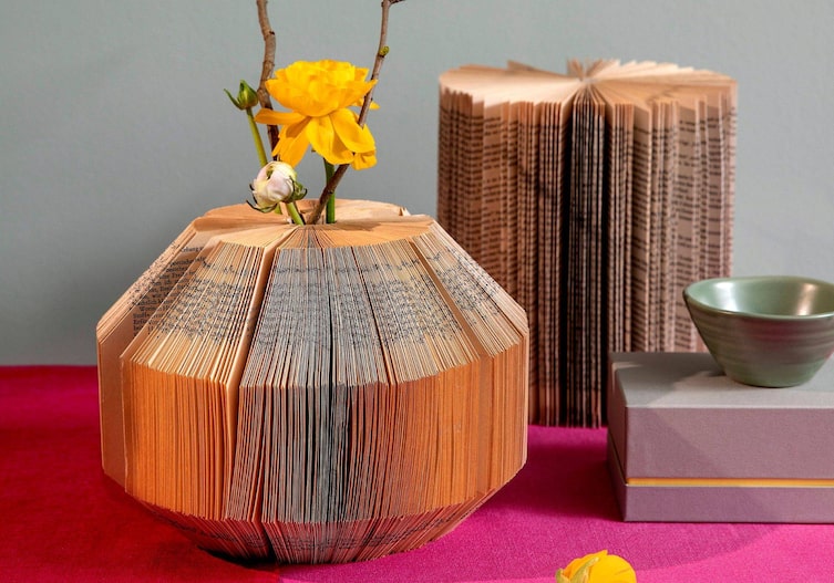 Eine Blumenvase aus gefalteten alten Buchseiten.