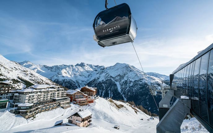 Gondel hoch über Sölden mit Hotels und Bergen im Hintergrund