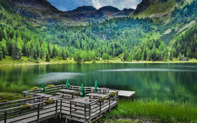 Gebirgssee von Wald und Bergen umgeben