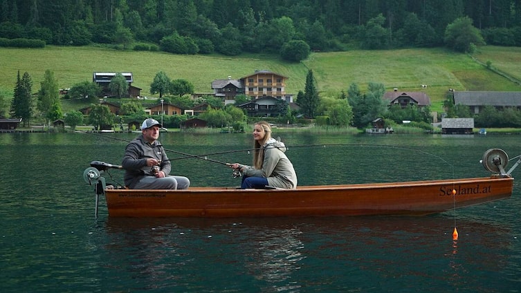 Markus Limarutti und Paula Bründl fischen auf einem Boot am Weissensee
