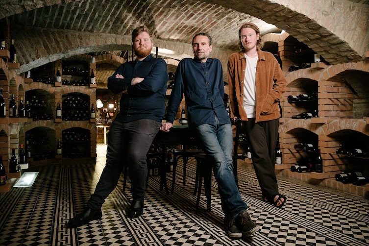 Lukas, Markus und Manuel Mraz bei einem gemeinsamen Foto im Weinkeller des Restaurants Mraz & Sohn