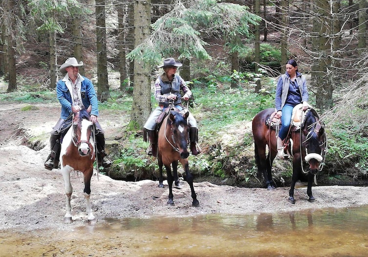 Ausritt mit der Betreiberin der Stonehill Ranch, Margit Kern, sowie den Gästen Nik und Nina mit Pferden am Bach