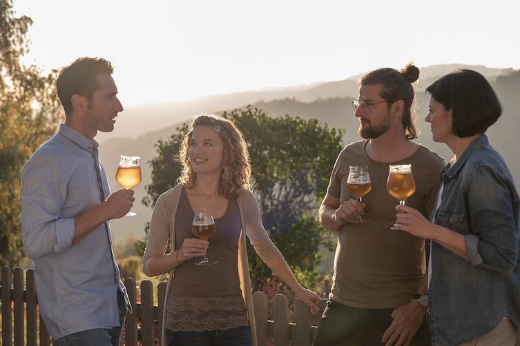 Vier Personen genießen ein Glas Bier.