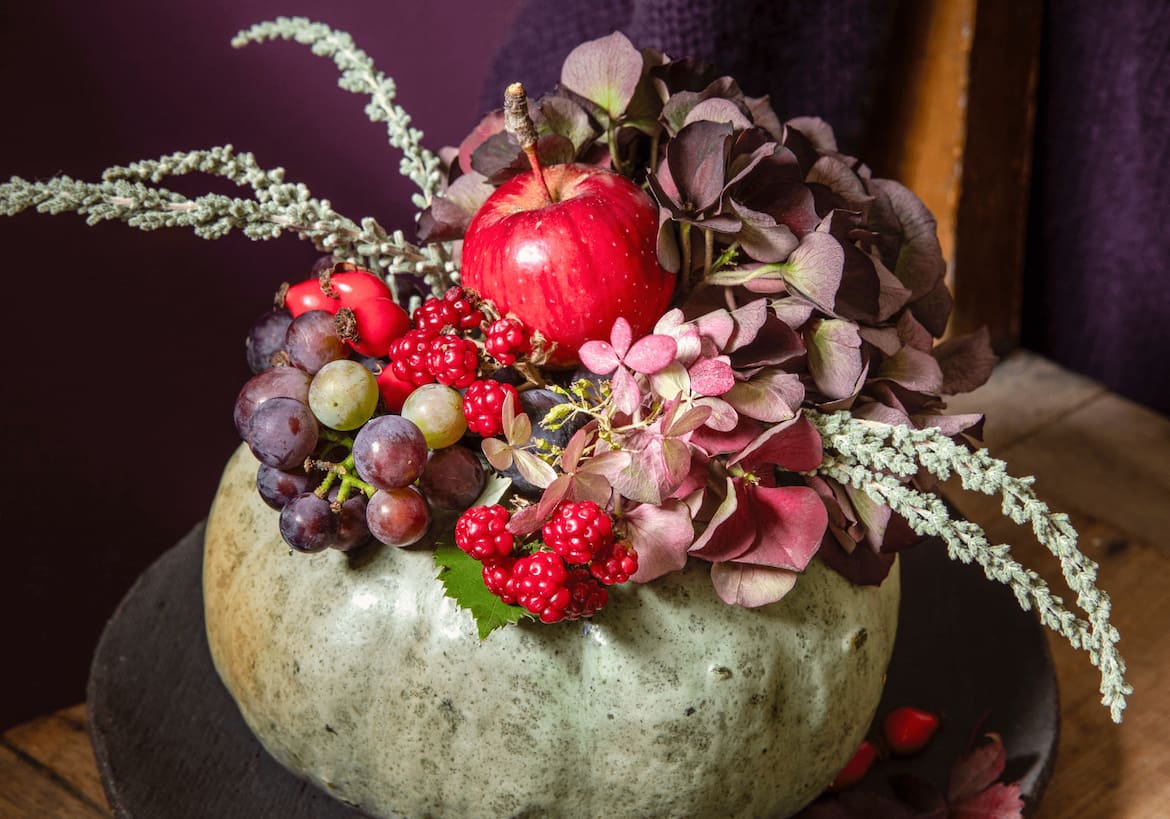 Kürbis mit herbstlicher Deko gefüllt