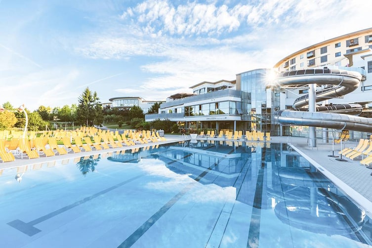 Zu sehen ist ein Schwimmbecken mit Rutsche in der Therme Stegersbach.