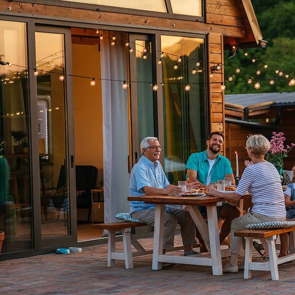 familie sitzt abends im garten bei grillfest