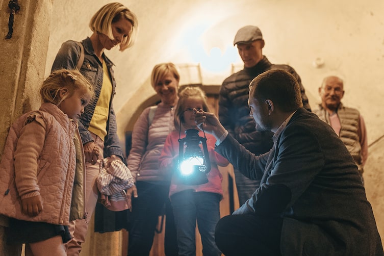 Eine Gruppe bei einer Führung durch das Schloss mit Laterne.