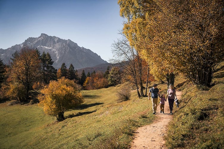 Familie beim Wandern im herbstlichen Berchtesgadener Land vor dem Watzmann-Massiv.