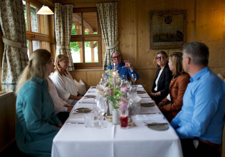 Die Gäste unterhalten sich am Esstisch.