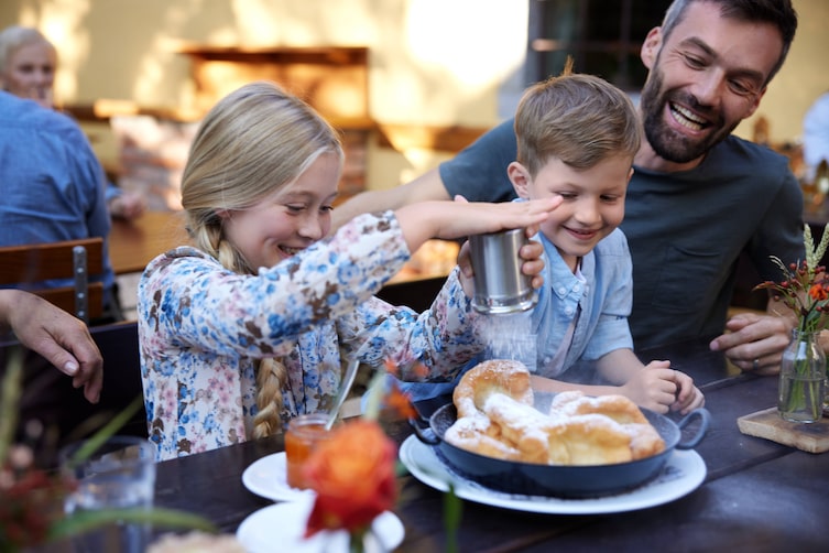 Eine Familie freut sich über die servierte Nachspeise.