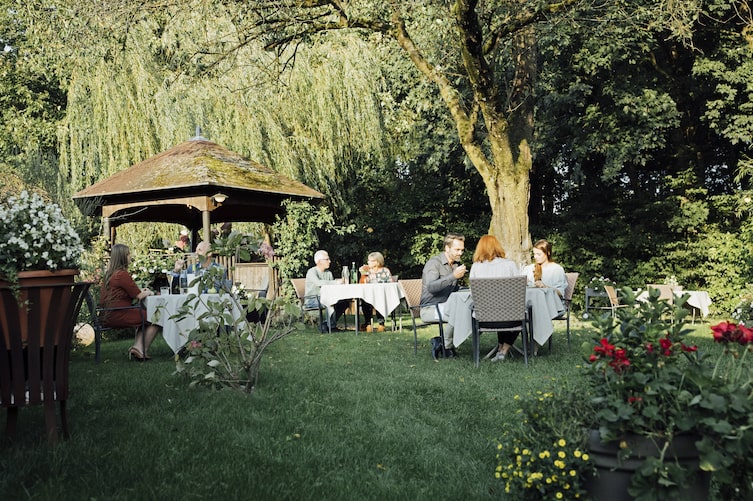 Gäste sitzen im Gastgarten des Restaurants Waldschänke in Grieskirchen.