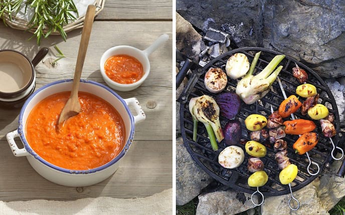 Links: Paprika-Pfefferoni-Sauce in weißem Emailletopf mit Holzlöffel, kleine Schüssel daneben, frischer Rosmarin im Hintergrund auf rustikalem Holztisch. Rechts: Gusseiserner Grillrost über offener Glut: Lauchzwiebeln, Rote Rüben, kleine Erdäpfel, Paprika und Fleischspieße auf Steinunterlage.