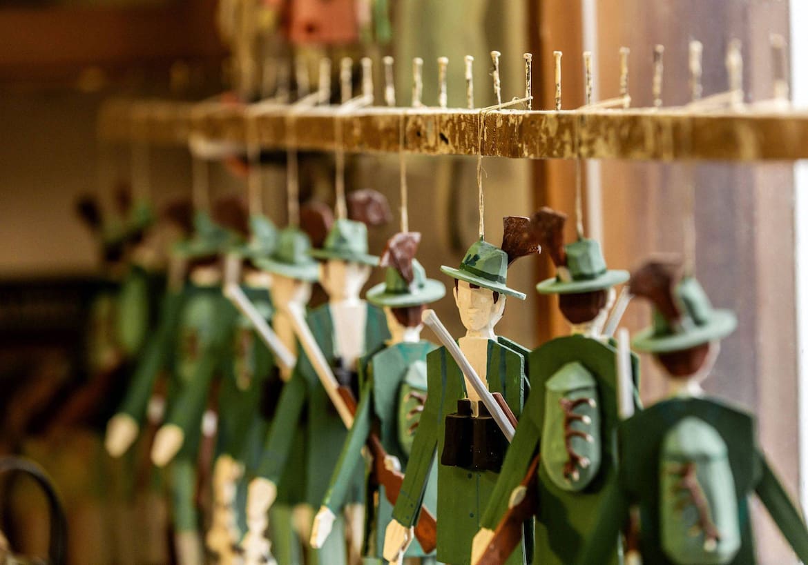 Mit Gamsbart, Gewehr und Rucksack: Markus Wagners Waidmänner, die hier von der Leiste baumeln, sind für die Jagd bestens gerüstet.