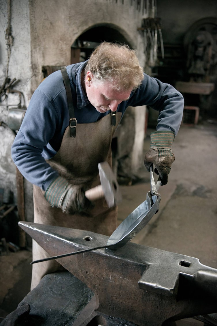 Mit Kraft und Geschick bringt der Schmied die Pfanne in Form.