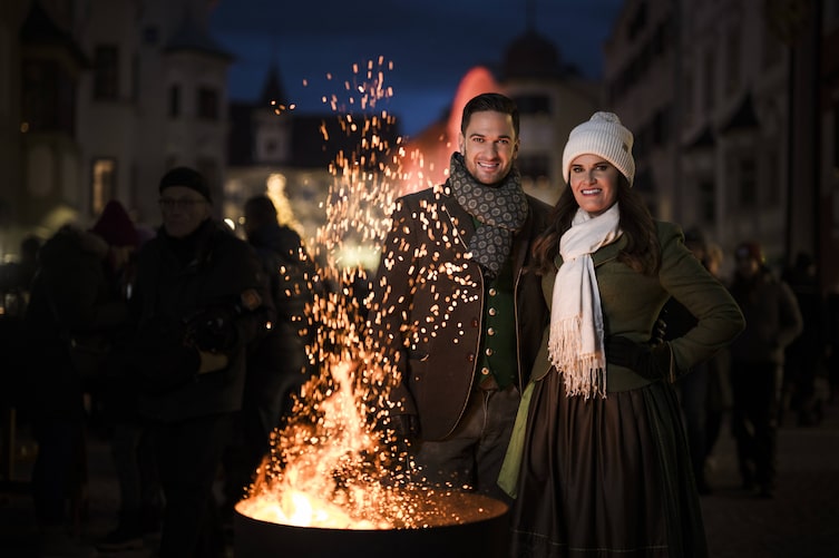 Richie Deutinger und Conny Bürgler stehen bei einer Feuerschale am TIroler Weihnachtsmarkt.