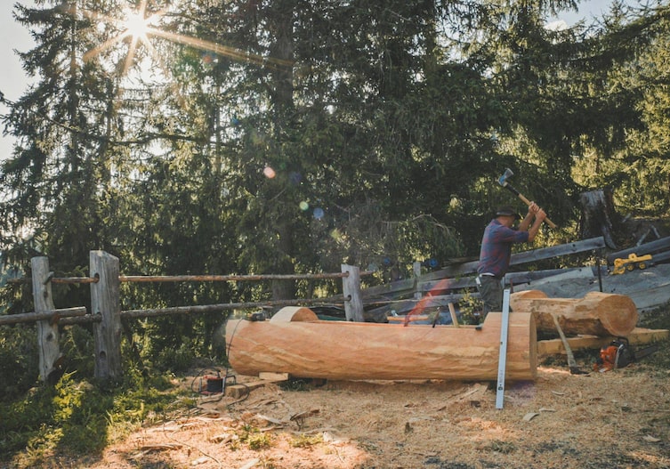 Bergbauer Anton Rainer-Pranter bei der Arbeit an einem Holztrog, Servus
