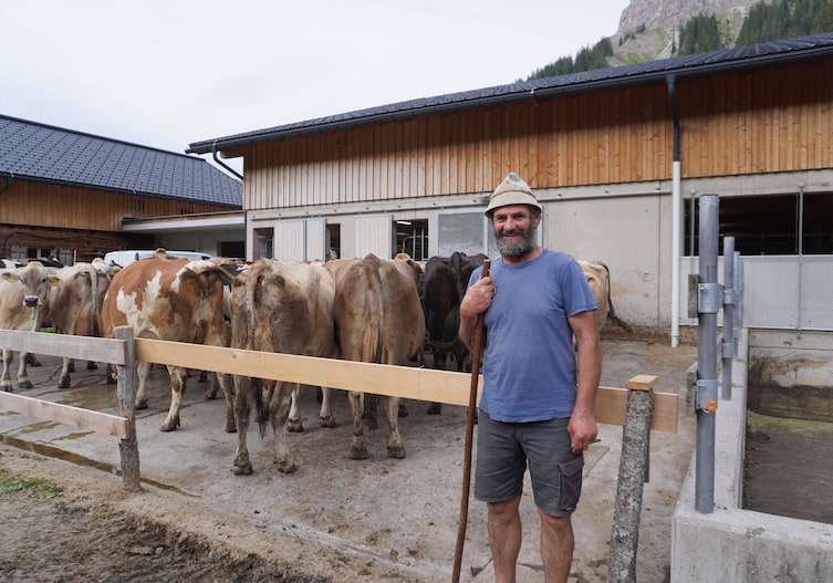Lothar Rinderer posiert für ein Foto mit den Kühen auf der Hutla-Alpe