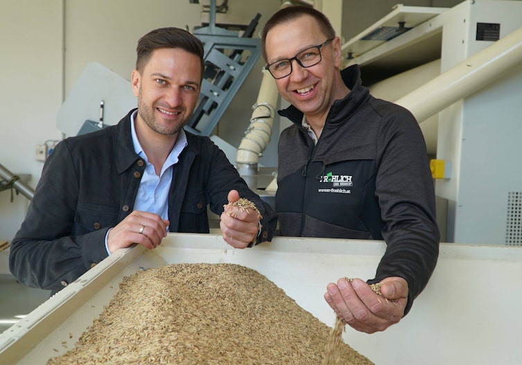 Richard Deutinger (links) posiert für ein Foto mit Reisbauer Ewald Fröhlich (rechts) und Reishaufen