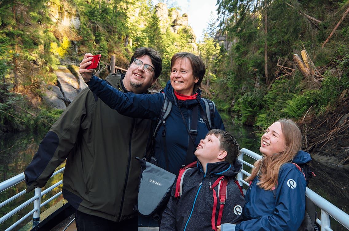 Eine Familie in Sachsen geht wandern im Wald.